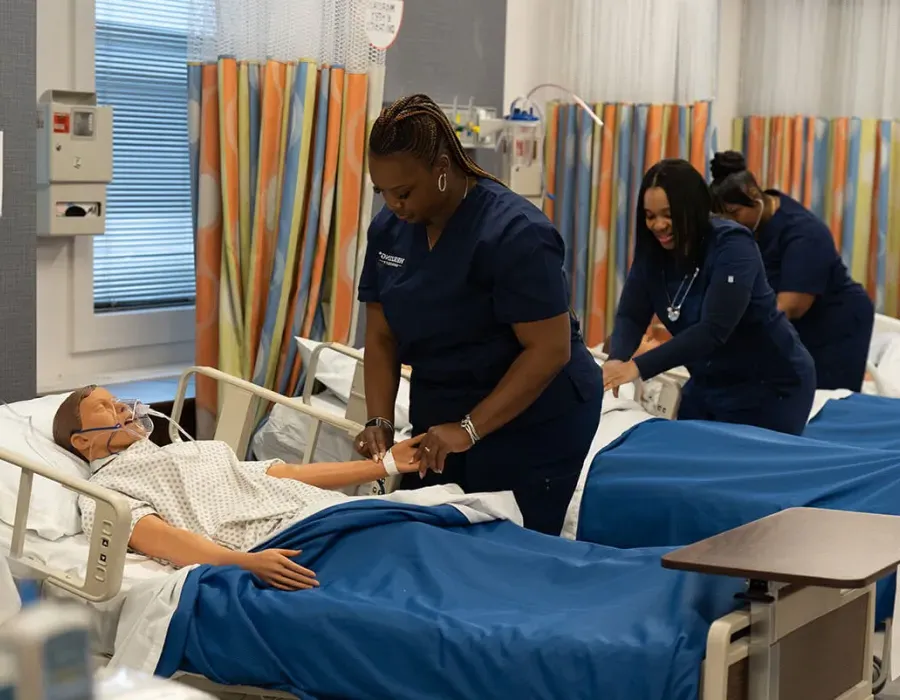 Herzing online nursing students training on mannequins during intensive experience